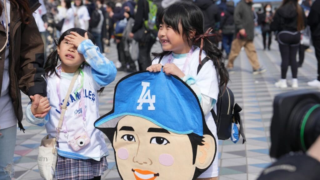 Mar 18, 2025; Bunkyo, Tokyo, JPN; A young Los Angeles Dodgers fan is interviewed while holding a caricature of designated hitter Shohei Ohtani (17) before the game against the Chicago Cubs during the Tokyo Series at Tokyo Dome.