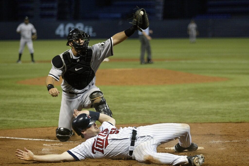 August 24, 2005; Minneapolis, MN, USA; Chicago White Sox catcher #12 AJ Pierzynski shows the ball to the umpire after he tags out Minnesota Twins catcher #55 Mike Redmond at home to end the sixth inning at the Metrodome.
