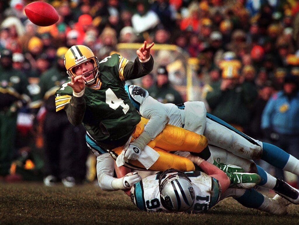 Green Bay Packers quarterback Brett Favre releases a shuttle pass to Dorsey Levens for a first down while in the grasp of Carolina Panthers linebacker Kevin Green during the third quarter of the 1997 NFC Championship game Sunday, January 12, 1997 at Lambeau Field in Green Bay, Wis.(Milwaukee Journal Sentinel photo by Dale Guldan)