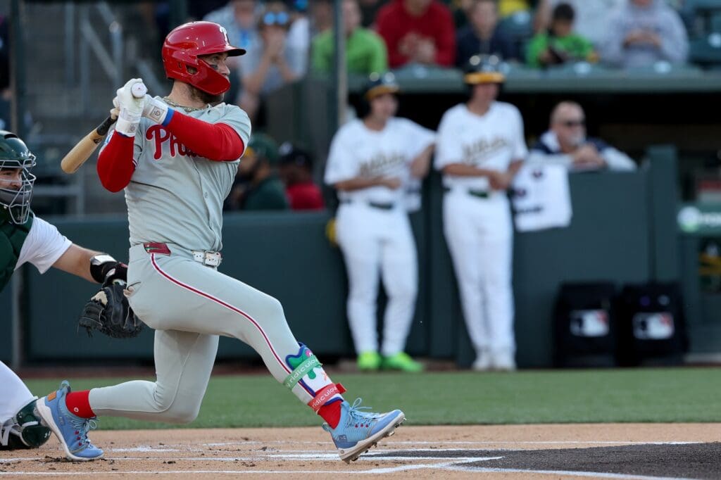 May 24, 2025; West Sacramento, California, USA; Philadelphia Phillies first baseman Bryce Harper (3) hits an RBI single against the Athletics during the first inning at Sutter Health Park.