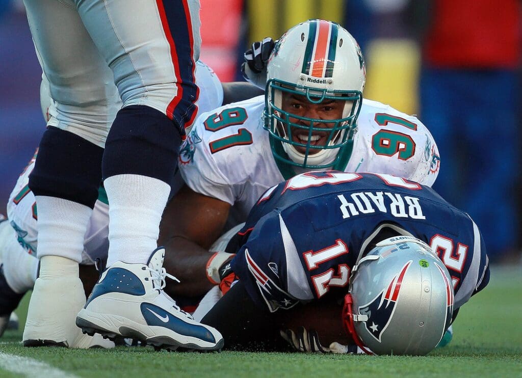 122411 Miami Dolphins outside linebacker Cameron Wake (91) drops New England Patriots quarterback Tom Brady (12) after a one yard gain in the second quarter at Gillette Stadium. (Allen Eyestone/The Palm Beach Post) Miami Dolphins Vs New England Patriots