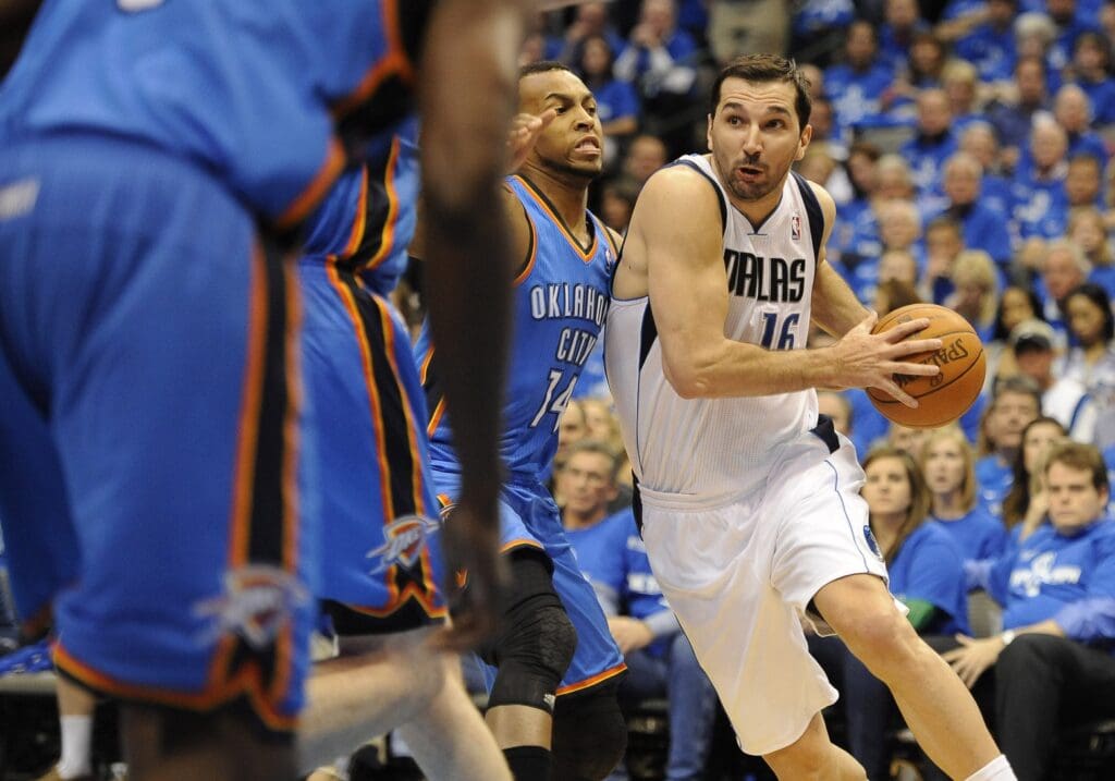 Dallas Mavericks small forward Peja Stojakovic (16) drives under the basket as Oklahoma City Thunder shooting guard Daequan Cook (14) defends during the second quarter of game one of the western conference finals of the 2011 NBA playoffs at the American Airlines Center.