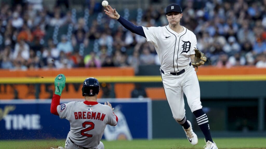 May 14, 2025; Detroit, Michigan, USA; Detroit Tigers shortstop Trey Sweeney (27) makes a throw to first to complete a double play as Boston Red Sox third baseman Alex Bregman (2) slide onto second in the seventh inning at Comerica Park.