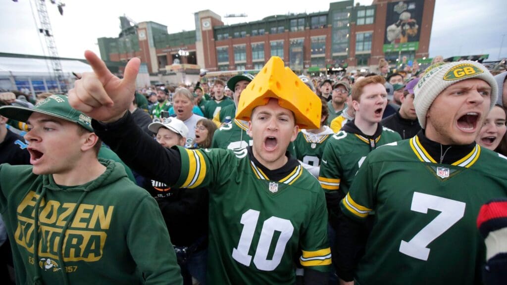 Green Bay Packers fan Theodore Schnell, center, of Howard, WI, cheers “Go Pack Go” during the first day of the NFL Draft presented by Bud Light at the Draft Theater Thursday, April 24, 2025, outside of Lambeau Field in Green Bay, Wisconsin.