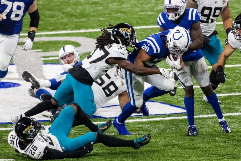Indianapolis Colts running back Jonathan Taylor (28) runs the ball while Jacksonville Jaguars cornerback Tre Herndon (37) defends in the second half at Lucas Oil Stadium.
