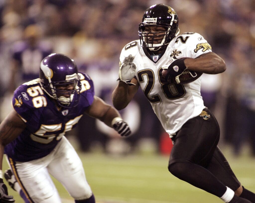 Nov 28, 2004; Minneapolis, MN, USA; Jacksonville Jaguars running back #28 Fred Taylor rushes for 13 yards in first half action at the Metrodome while Minnesota Vikings linebacker #56 EJ Henderson approaches. The Vikings and Jaguars are tied at the half 13-13.