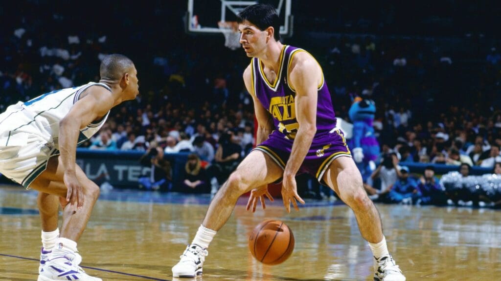 Dec 16, 1992; Charlotte, NC, USA; FILE PHOTO; Utah Jazz guard John Stockton (12) is defended by Charlotte Hornets guard Mugsy Bouges (left) at the Charlotte Arena.