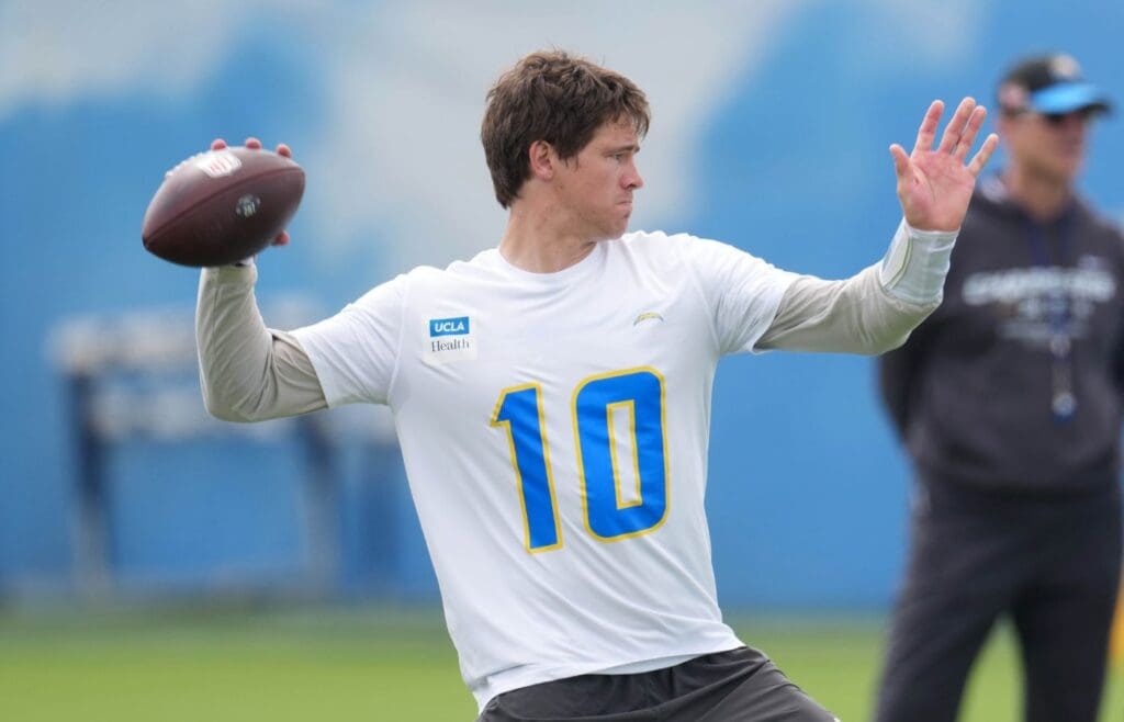 May 12, 2025; El Segundo, CA, USA; Los Angeles Chargers quarterback Justin Herbert (10) throws the ball as coach Jim Harbaugh watches during offseason workouts at The Bolt.