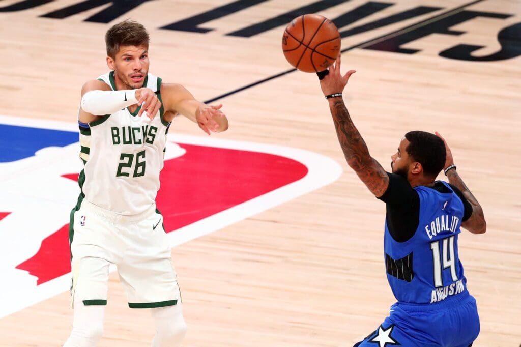 Aug 29, 2020; Lake Buena Vista, Florida, USA; Milwaukee Bucks guard Kyle Korver (26) passes the ball against Orlando Magic guard D.J. Augustin (14) during the second quarter in game five of the first round of the 2020 NBA Playoffs at AdventHealth Arena. Mandatory Credit: Kim Klement-USA TODAY Sports