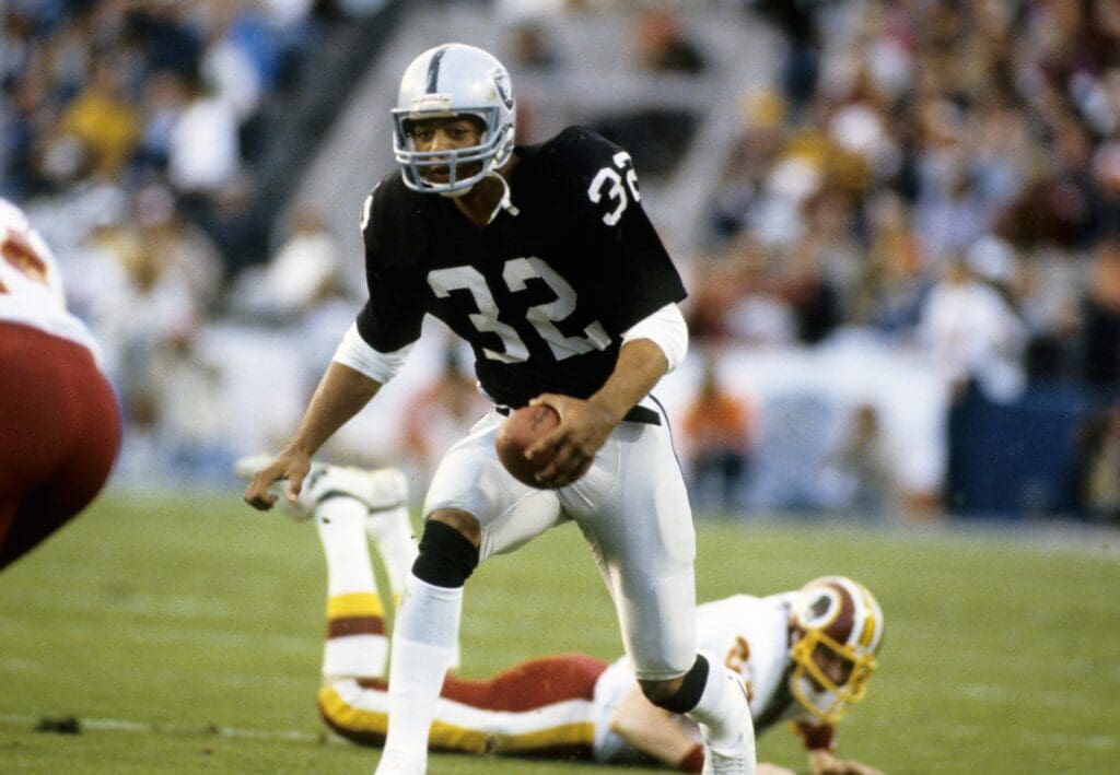 Jan 30, 1983; Pasadena, CA, USA; FILE PHOTO; Los Angeles Raiders running back Marcus Allen (32) carries the ball against the Washington Redskins during Super Bowl XVIII at Tampa Stadium. The Raiders defeated Redskins 38-9.