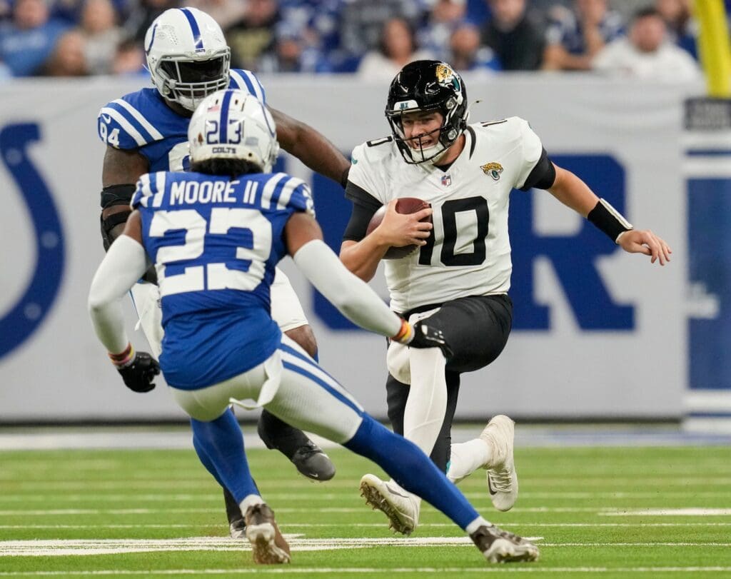Jacksonville Jaguars quarterback Mac Jones (10) slides as Indianapolis Colts cornerback Kenny Moore II (23) moves in to tackle Sunday, Jan. 5, 2025, during a game against the Jacksonville Jaguars at Lucas Oil Stadium in Indianapolis.