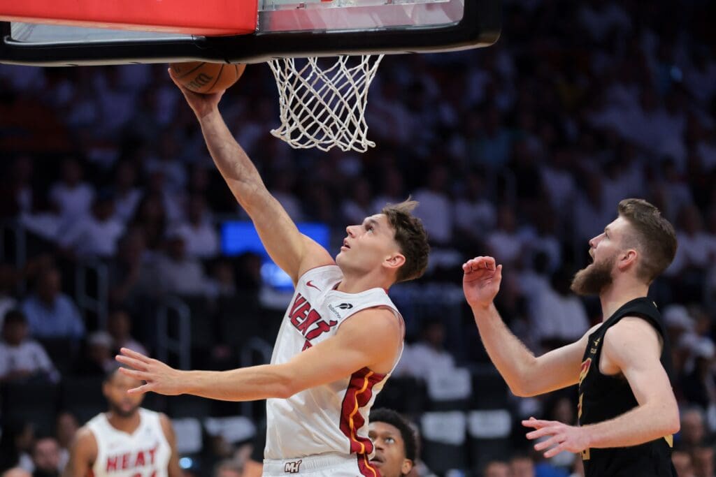 Apr 28, 2025; Miami, Florida, USA; Miami Heat guard Pelle Larsson (9) scores past Cleveland Cavaliers forward Dean Wade (32) in the first quarter during game four for the first round of the 2025 NBA Playoffs at Kaseya Center.