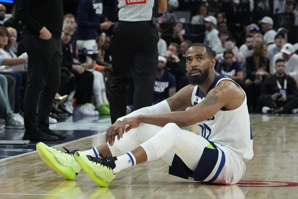 May 6, 2025; Minneapolis, Minnesota, USA; Minnesota Timberwolves guard Mike Conley (10) rests on the floor after taking a charge by a member of the Golden State Warriors in the third quarter during game one of the second round for the 2025 NBA Playoffs at Target