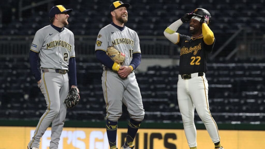 May 22, 2025; Pittsburgh, Pennsylvania, USA; Milwaukee Brewers second baseman Brice Turang (2) and first baseman Rhys Hoskins (12) joke with Pittsburgh Pirates designated hitter Andrew McCutchen (22) as play resumes in the sixth inning after a lengthy rain delay at PNC Park.