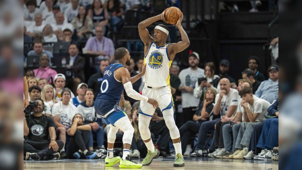 May 14, 2025; Minneapolis, Minnesota, USA; Golden State Warriors forward Jimmy Butler III (10) holds the ball over his head as Minnesota Timberwolves guard Mike Conley (10) plays degrees in the first half during game five of the second round for the 2025 NBA Playoffs at Target Center