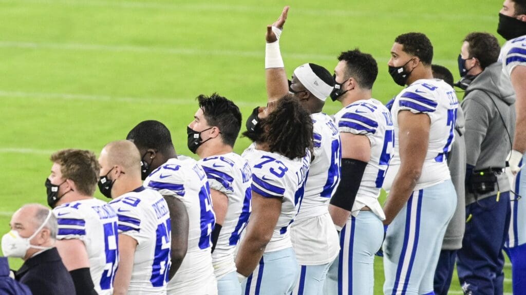 Dec 8, 2020; Baltimore, Maryland, USA; Dallas Cowboys center Joe Looney (73) points towards the sky while standing with his teammates during the playing of the national anthem before the game against the Baltimore Ravens at M&T Bank Stadium