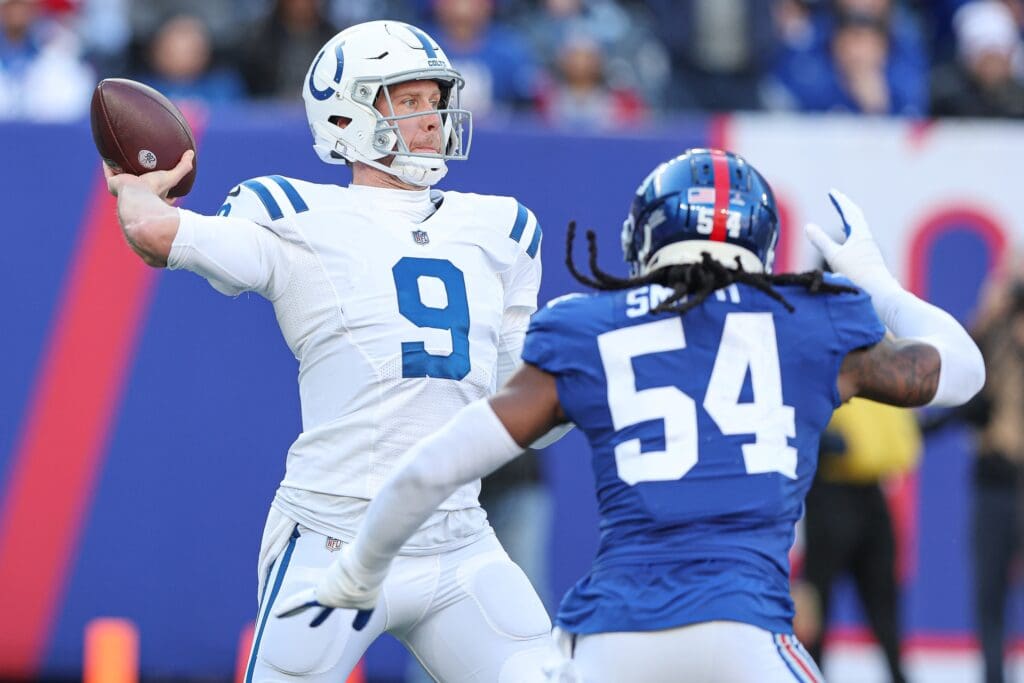 Jan 1, 2023; East Rutherford, New Jersey, USA; Indianapolis Colts quarterback Nick Foles (9) throws the ball as New York Giants linebacker Jaylon Smith (54) pursues during the first half at MetLife Stadium. Mandatory Credit: Vincent Carchietta-USA TODAY Sports