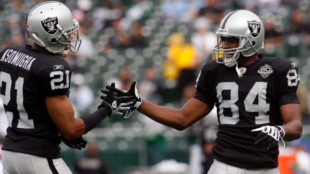 October 18, 2009; Oakland, CA, USA; Oakland Raiders wide receiver Javon Walker (84) shakes hands with cornerback Nnamdi Asomugha (21) before the start of the Raiders game against the Philadelphia Eagles at Oakland-Alameda County Coliseum