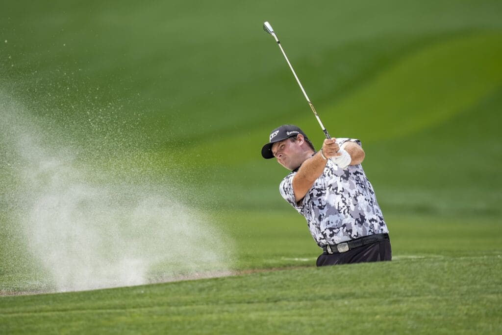 May 15, 2025; Charlotte, North Carolina, USA; Patrick Reed hits out of the bunker on the seventh hole during the first round of the PGA Championship golf tournament at Quail Hollow.