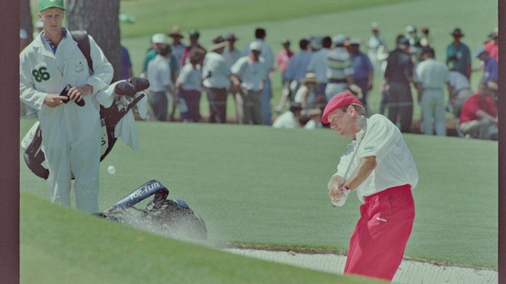 4/14/1995; Augusta, Georgia, USA; Payne Stewart chips the ball out of a bunker with caddie in the background at the Augusta National Golf Course during the 1995 Masters.