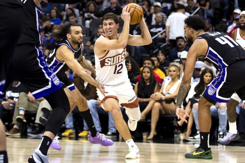 Apr 13, 2025; Sacramento, California, USA; Phoenix Suns guard Collin Gillespie (12) drives past Sacramento Kings guard Devin Carter (22) during the fourth quarter at Golden 1 Center.