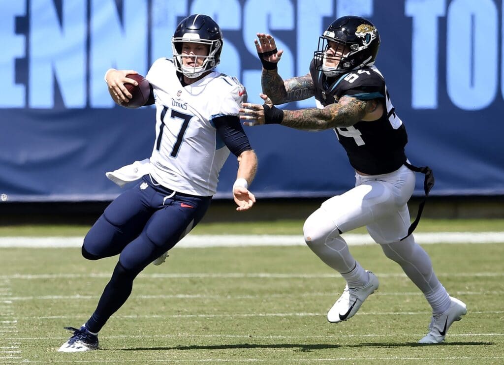 Tennessee Titans quarterback Ryan Tannehill (17) scrambles up the field away from Jacksonville Jaguars defensive end Cassius Marsh (54) at Nissan Stadium in Nashville on Sept. 20, 2020. The Titans won their home opener 33-30.