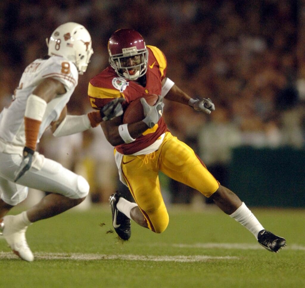 Jan 4, 2006; Pasadena, CA, USA; Southern California Trojans tailback (5) Reggie Bush runs around Texas Longhorns cornerback (8) Cedric Griffin during the 1st quarter of the Rose Bowl Game at the Rose Bowl in Pasadena, California. Bush decided to forego his last year of eligibility and declared himself eligible for the 2006 NFL Draft.