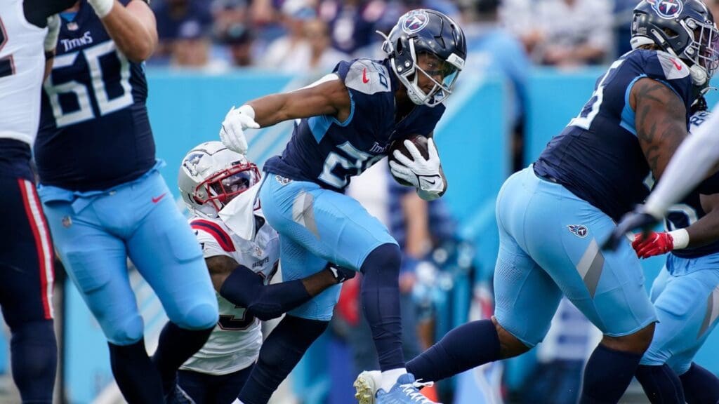Tennessee Titans running back Tony Pollard (20) is tripped up by New England Patriots cornerback Jonathan Jones (31) during the first quarter at Nissan Stadium in Nashville, Tenn., Sunday, Nov. 3, 2024.