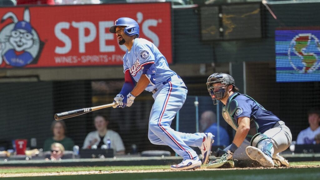 May 4, 2025; Arlington, Texas, USA; Texas Rangers shortstop Corey Seager (5) hits an rbi single during the third inning against the Seattle Mariners at Globe Life Field.