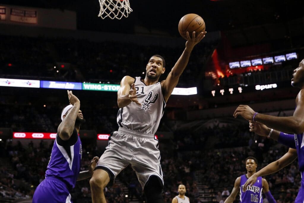 Dec 29, 2013; San Antonio, TX, USA; San Antonio Spurs forward Tim Duncan (21) drives to the basket past Sacramento Kings center DeMarcus Cousins (left) during the first half at the AT&T Center.