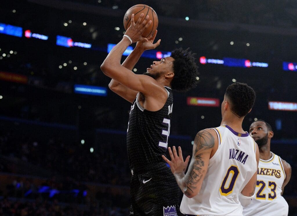 March 24, 2019; Los Angeles, CA, USA; Sacramento Kings guard Corey Brewer (33) shoots ahead of Los Angeles Lakers forward LeBron James (23) and forward Kyle Kuzma (0) during the first half at Staples Center. Mandatory Credit: Gary A. Vasquez-USA TODAY Sports