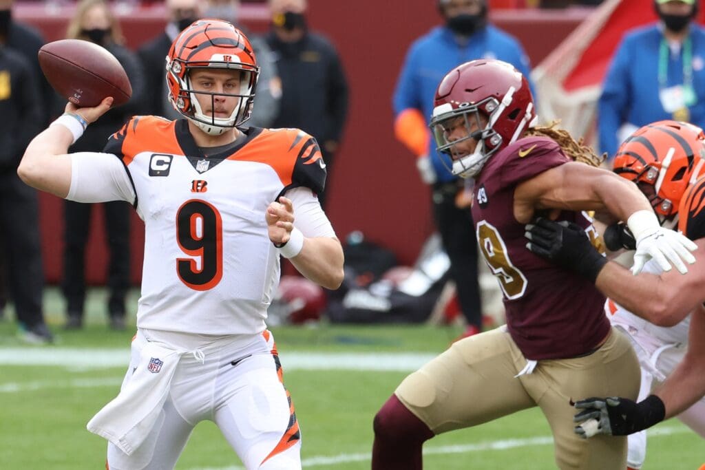 Nov 22, 2020; Landover, Maryland, USA; Cincinnati Bengals quarterback Joe Burrow (9) passes the ball under pressure from Washington Football Team defensive end Chase Young (99) in the second quarter at FedExField