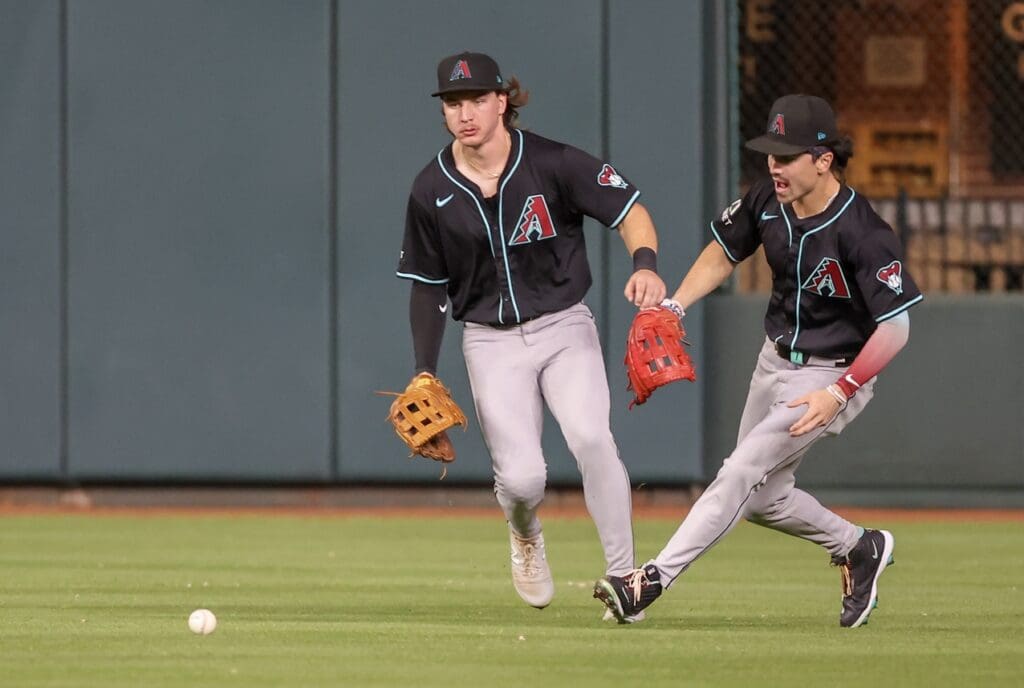 Sep 6, 2024; Houston, Texas, USA; Arizona Diamondbacks center fielder Jake McCarthy (31) and right fielder Corbin Carroll (7) play Houston Astros first baseman Jon Singleton (28) single in the second inning at Minute Maid Park.