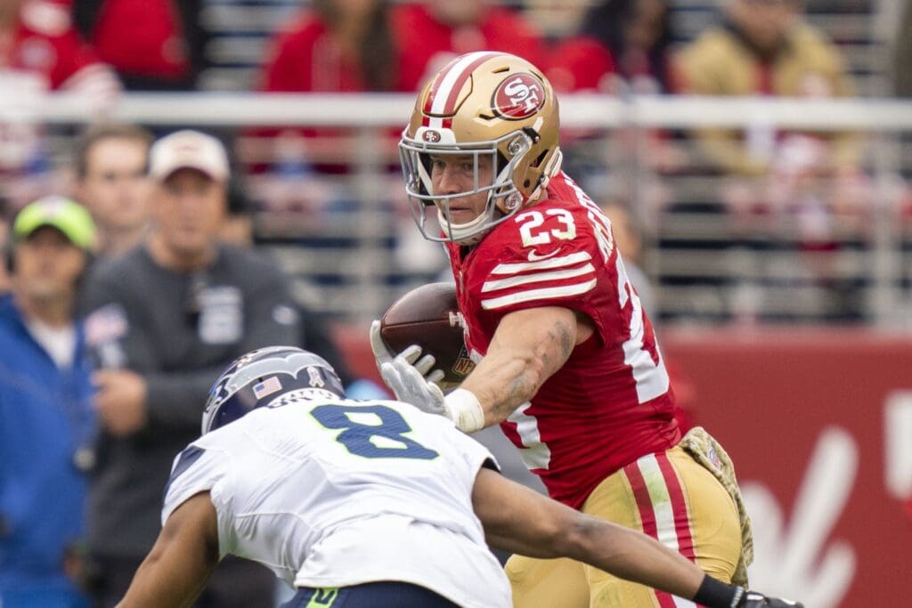 November 17, 2024; Santa Clara, California, USA; San Francisco 49ers running back Christian McCaffrey (23) runs against Seattle Seahawks cornerback Coby Bryant (8) during the second quarter at Levi's Stadium.