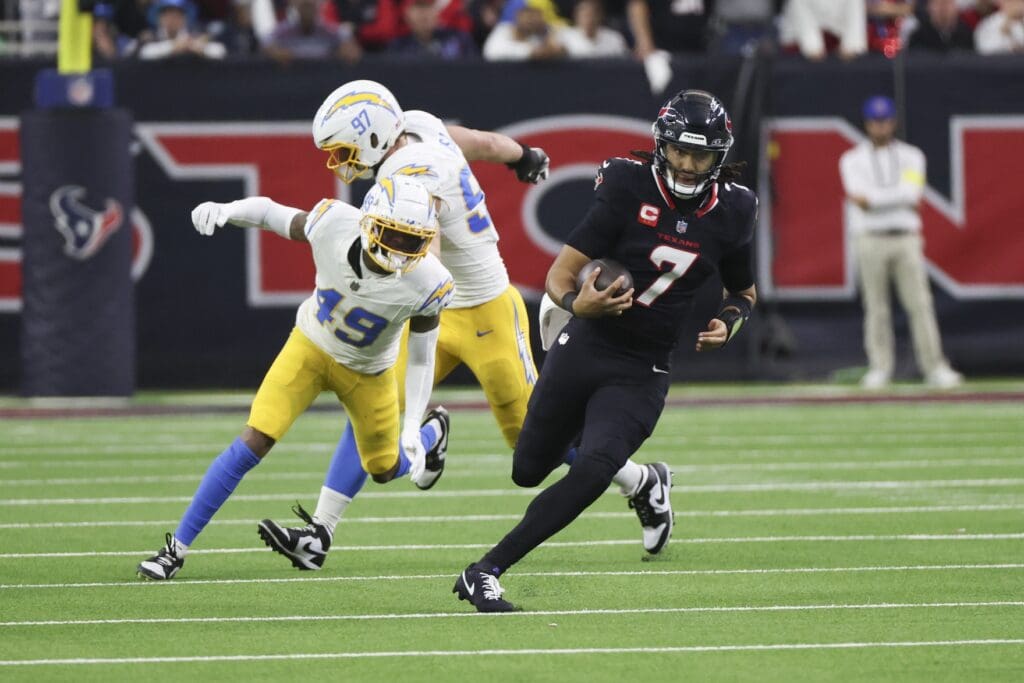 Jan 11, 2025; Houston, Texas, USA; Houston Texans quarterback C.J. Stroud (7) scrambles the rush for a first down in the second quarter against the Los Angeles Chargers in an AFC wild card game at NRG Stadium.