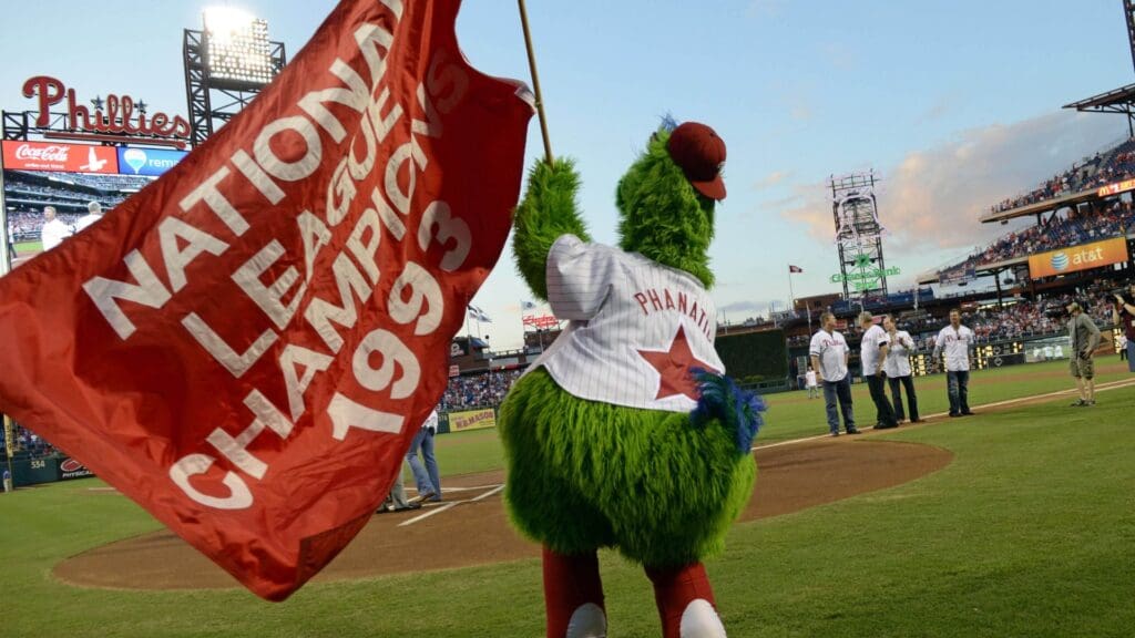 Aug 4, 2013; Philadelphia, PA, USA; Philadelphia Phillies mascot, the Phillie Phanatic, waves a flag honoring the 1993 National League Champion team before game against the Atlanta Braves at Citizens Bank Park. The Braves defeated the Phillies, 4-1