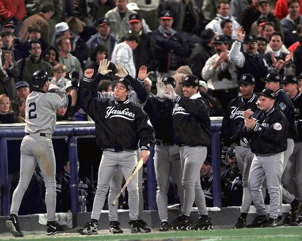 Oct 23, 1996; Atlanta, GA, USA; FILE PHOTO; New York Yankees shortstop Derek Jeter (2) is greeted by his team after he scores during game 4 of the 1996 World Series against the Atlanta Braves at Fulton County Stadium.