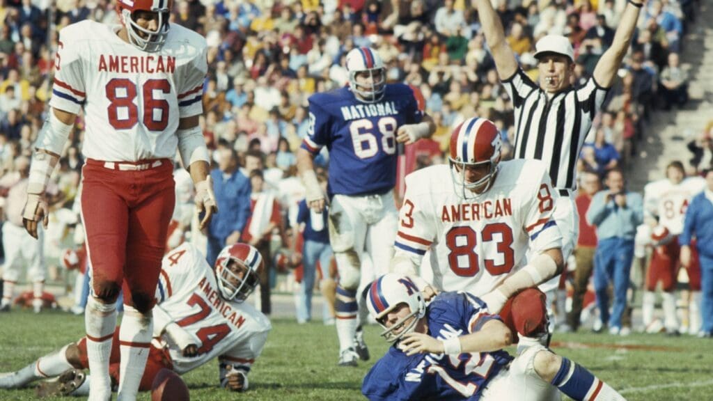 AFC linebacker Ted Hendricks (83) of the Baltimore Colts on the field NFC quarterback Roger Staubach (12) during the 1971 Pro Bowl at the Los Angeles Coliseum. The NFC defeated the AFC 27-6