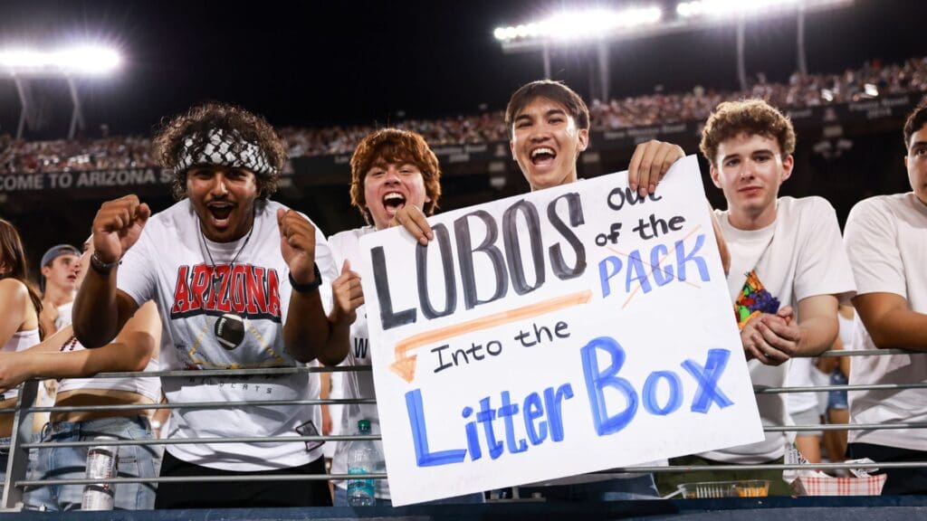Arizona Wildcats fans holding sign in Zone Zoo during third quarter at Arizona Stadium.