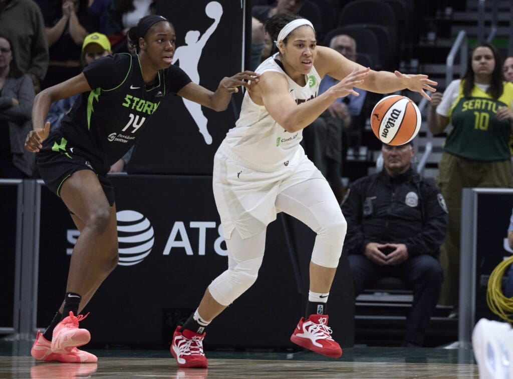May 30, 2025; Seattle, Washington, USA; Atlanta Dream forward Brionna Jones (24) reaches for the ball with Seattle Storm center Dominique Malonga (14) defending during the second half at Climate Pledge Arena.