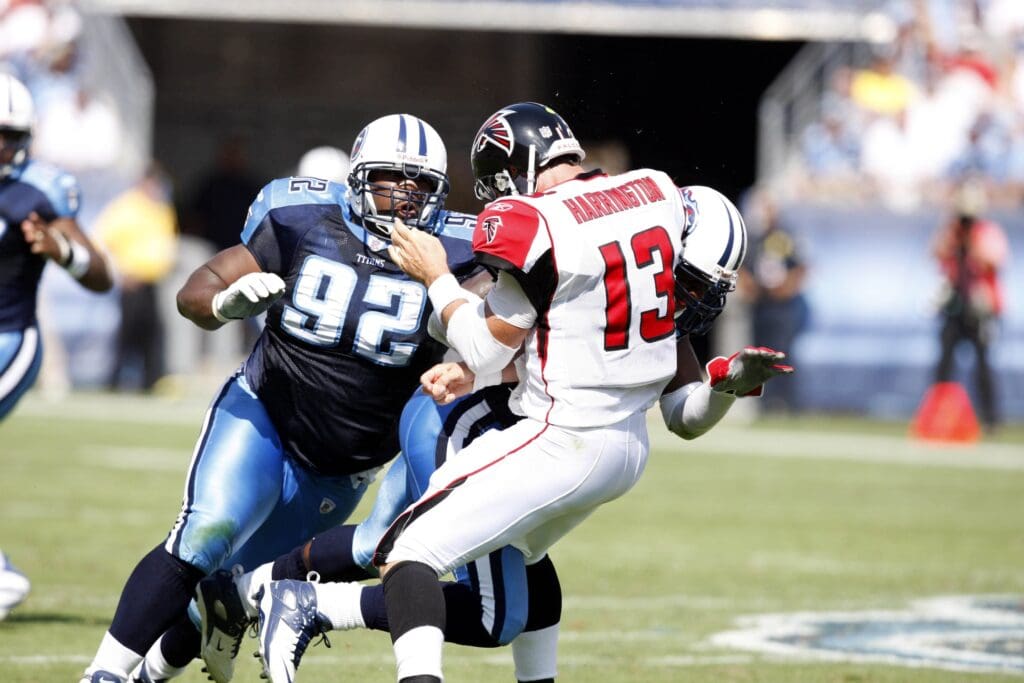 October 7, 2007; Nashville, TN, USA; Atlanta Falcons quarterback (13) Joey Harrington gets hit by Tennessee Titans defensive tackle (92) Albert Haynesworth and linebacker (53) Keith Bulluck after releasing the ball in the first half at LP Field.