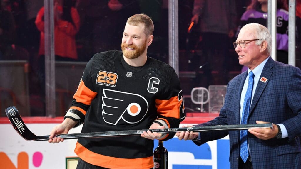 Mar 17, 2022; Philadelphia, Pennsylvania, USA; Philadelphia Flyers center Claude Giroux (28) receives a silver hockey stick from Bobby Clarke during a pregame ceremony honoring Giroux for his 1000th game as a Flyer before game against the Nashville Predators at Wells Fargo Center.