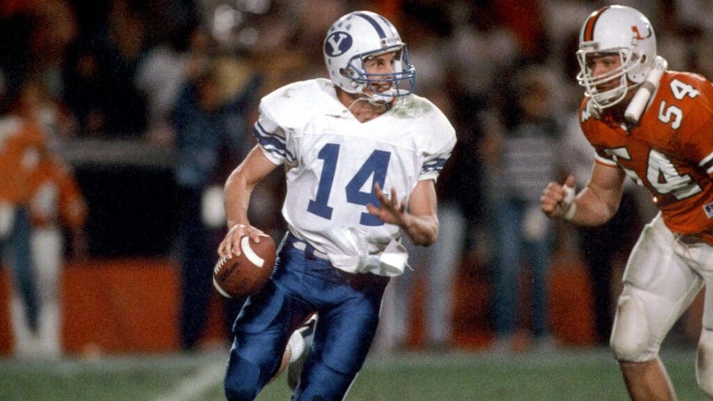 Dec 3, 1988; Miami, FL, USA; FILE PHOTO; Brigham Young quarterback Ty Detmer (14) is chased by Miami Hurricanes defensive end #54 BILL HAWKINS during the 1988 season at the Orange Bowl. Miami defeated BYU 41-17.