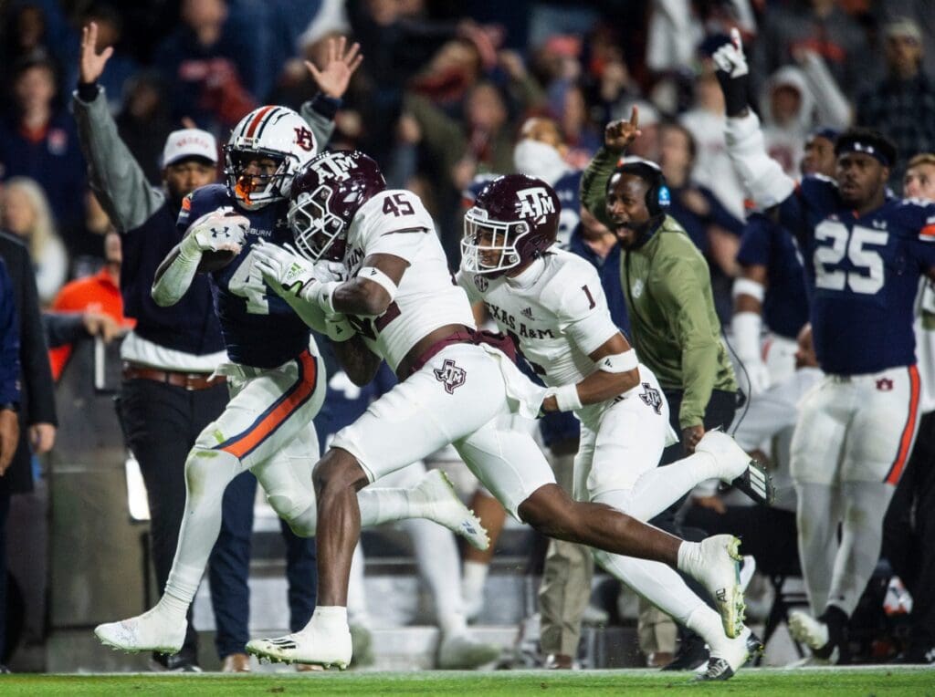 Auburn Tigers running back Tank Bigsby (4) runs the ball with Auburn Tigers interim head coach Carnell \"Cadillac\" Williams trailing him on the sideline as Auburn Tigers take on Texas A&M Aggies at Jordan-Hare Stadium in Auburn, Ala., on Saturday, Nov. 12, 2022.