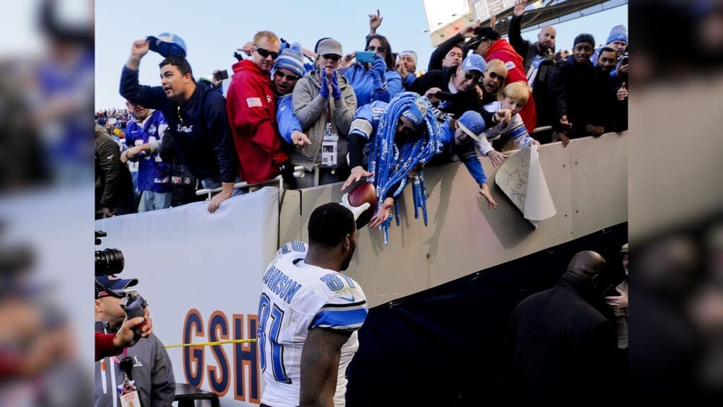 Nov 10, 2013; Chicago, IL, USA; Detroit Lions wide receiver Calvin Johnson (81) gives the ball to a fan after the Lions beat the Bears 21-19 at Soldier Field.