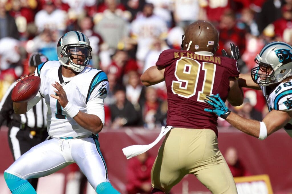 November 4, 2012; Landover, MD, USA; Carolina Panthers quarterback Cam Newton (1) prepares to throw the ball as Washington Redskins outside linebacker Ryan Kerrigan (91) chases in the first quarter at FedEx Field.