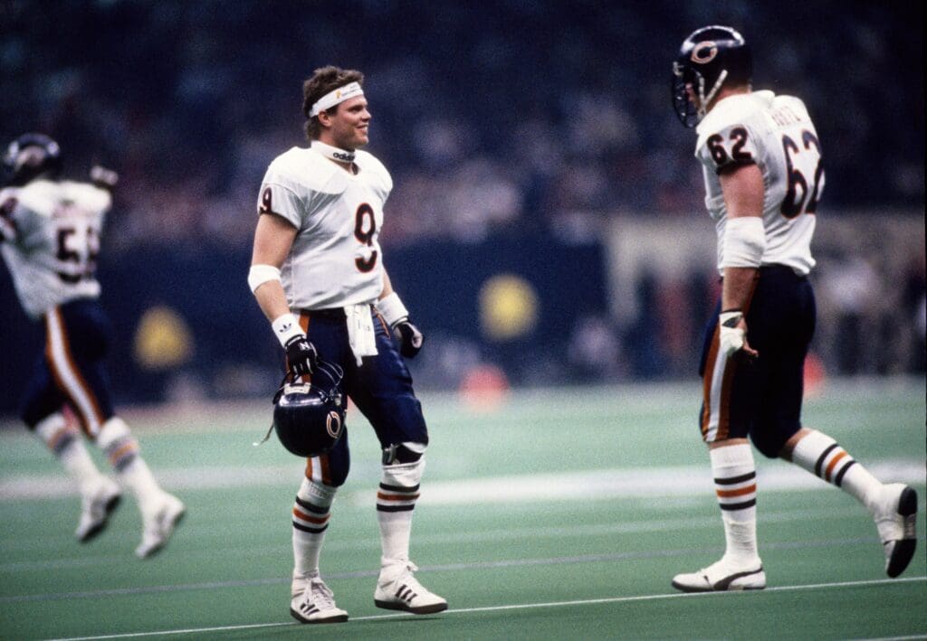 Jan 26, 1986; New Orleans, LA, USA: FILE PHOTO; Chicago Bears quarterback Jim McMahon (9) with guard Mark Bortz (62) on the field during Super Bowl XX against the New England Patriots at the Superdome. Chicago defeated New England 46-10.
