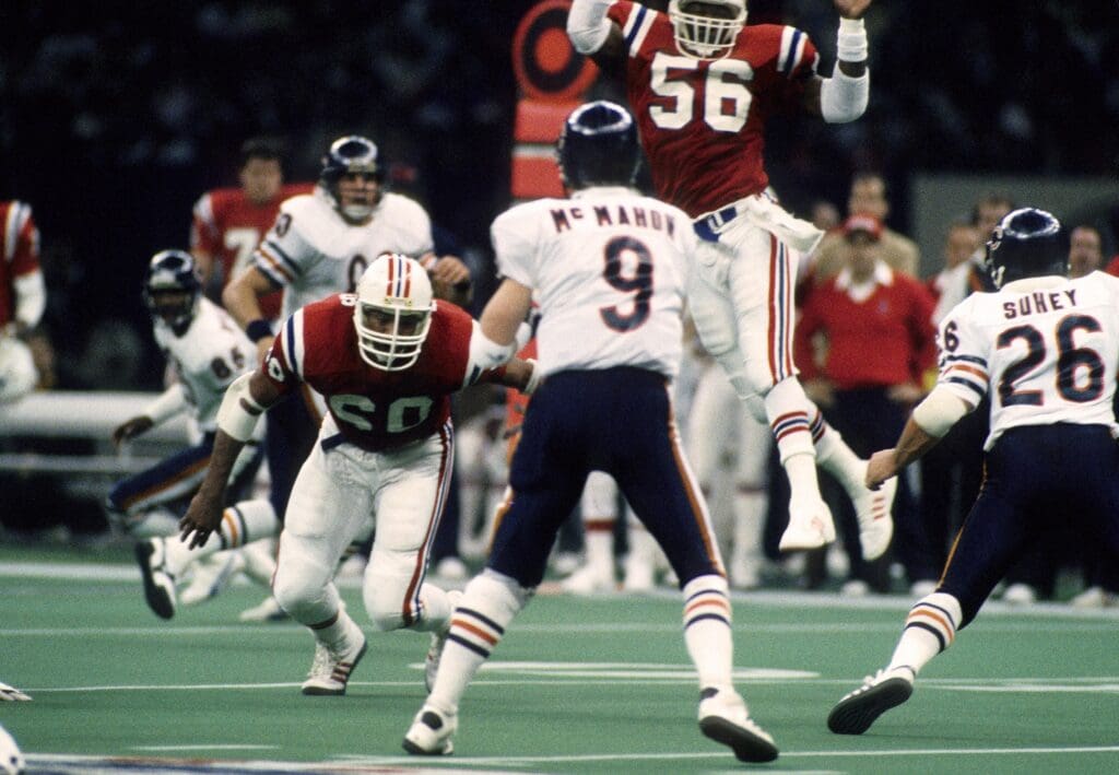 Jan 26, 1986; New Orleans, LA, USA; FILE PHOTO; Chicago Bears quarterback Jim McMahon (9) attempts to pass under pressure from New England Patriots defenders Garin Veris (60) and Andre Tippett (56) during Super Bowl XX at the Superdome. The Bears defeated the Patriots 46-10.