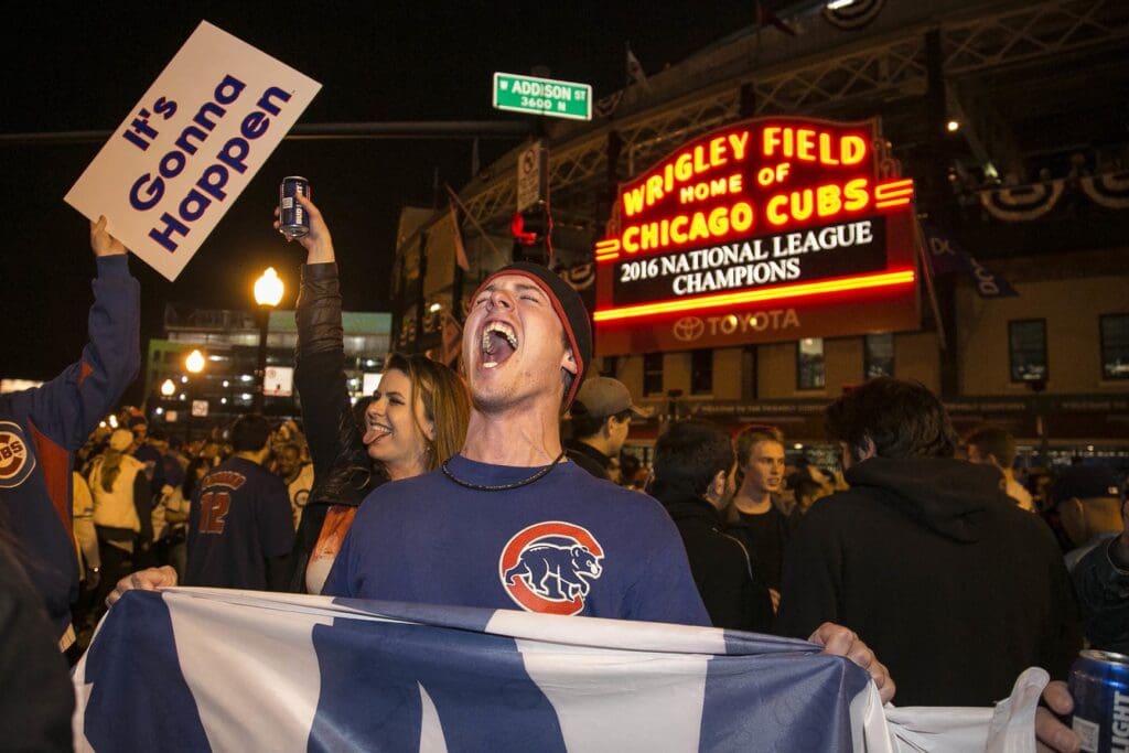 A Chicago Cubs fan hold a \"W\" flag as he celebrates outside Wrigley Field after the Cubs won the National League pennant in 2016. Cubs fans