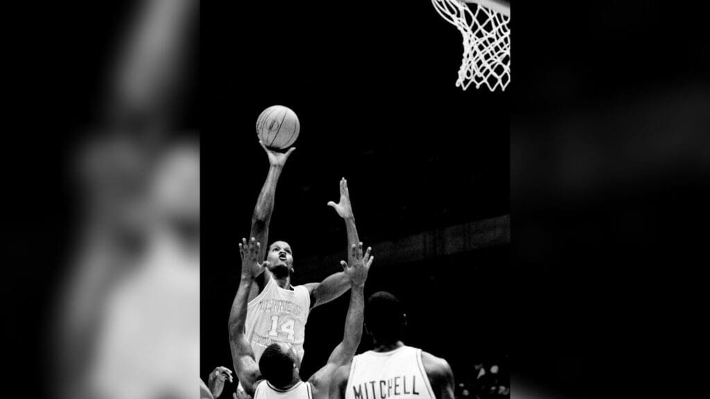 Tennessee star Dale Ellis (14) goes high in the air for a shot over the outstretched arms of LSU defenders Jerry Reynolds and Leonard Mitchell in the SEC quarterfinals of the SEC tournament in Birmingham March 11, 1983. The Vols, with 33 points from Ellis, edges LSU 74-71 in overtime. 83then03 037a